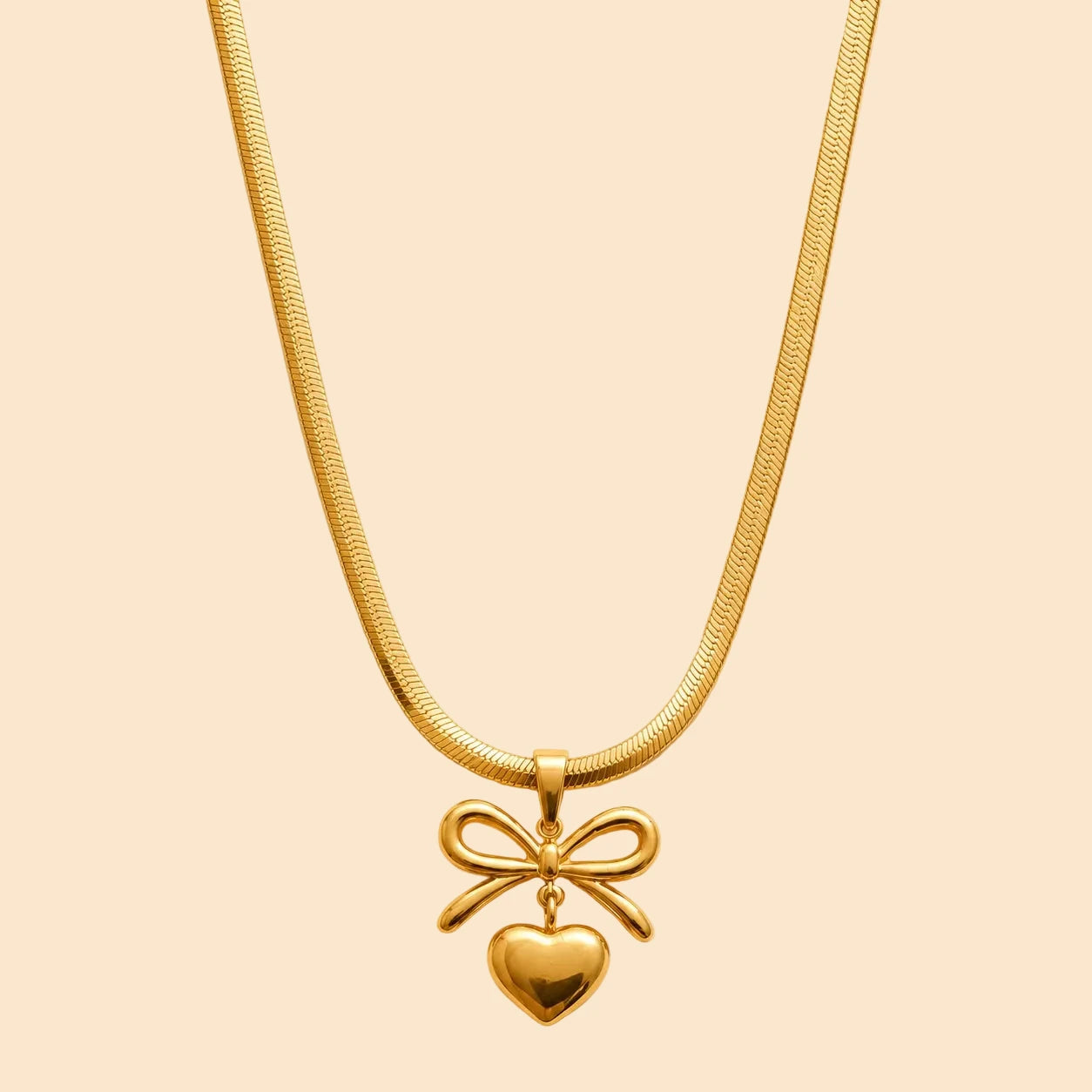 Gold necklace with a heart and bow pendant