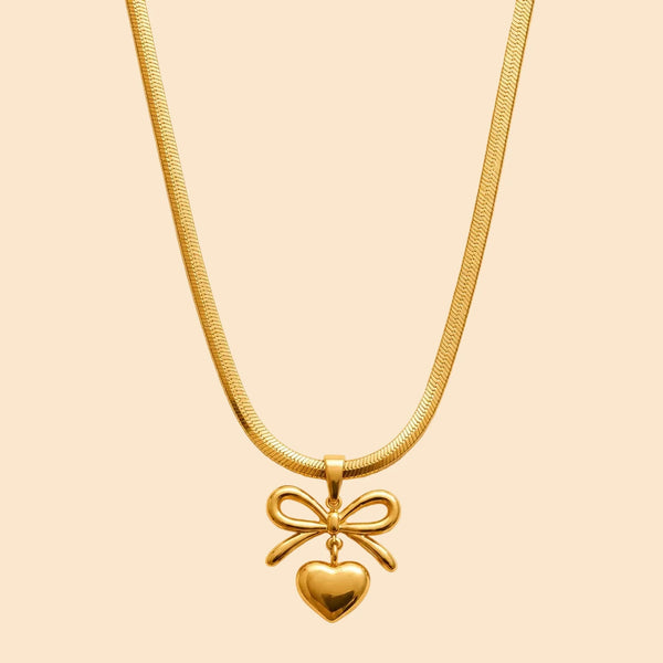 Gold necklace with a heart and bow pendant