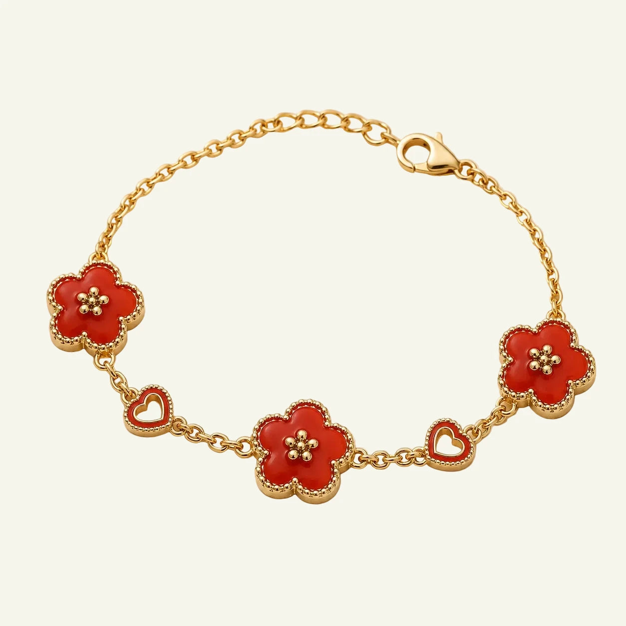 Gold bracelet with red enamel clover flower charms and open heart charms on cable chain